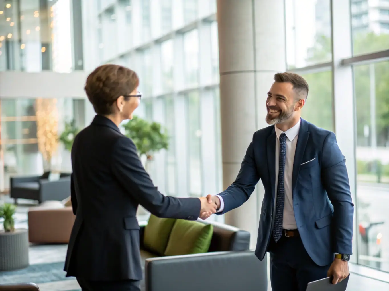 A professional sales representative is shaking hands with a Swipejoy executive in a modern office setting, symbolizing a successful partnership agreement.